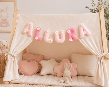 Children's play area with a name galrand, teepee, cushions, and a 'ALURA' banner in a cozy room.