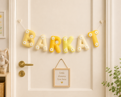 Decorative wall letters spelling 'BARKAT' with flowers on a light-colored wall.