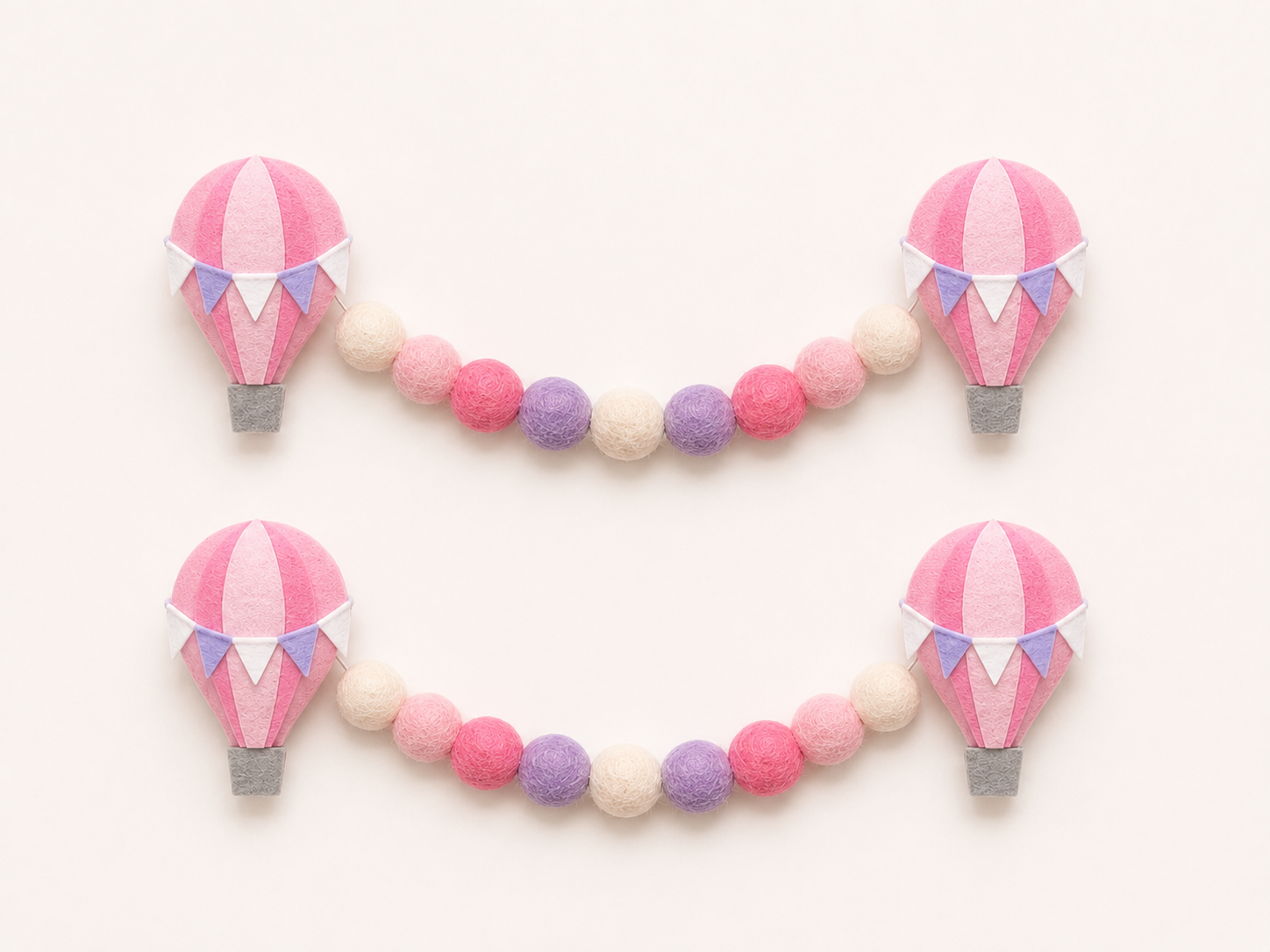 Decorative garland with pink hot air balloon and bead elements on a white background