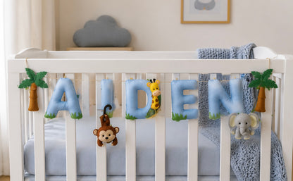 Baby crib with personalized name bunting 'Aiden' and animal-themed decorations in a nursery setting.
