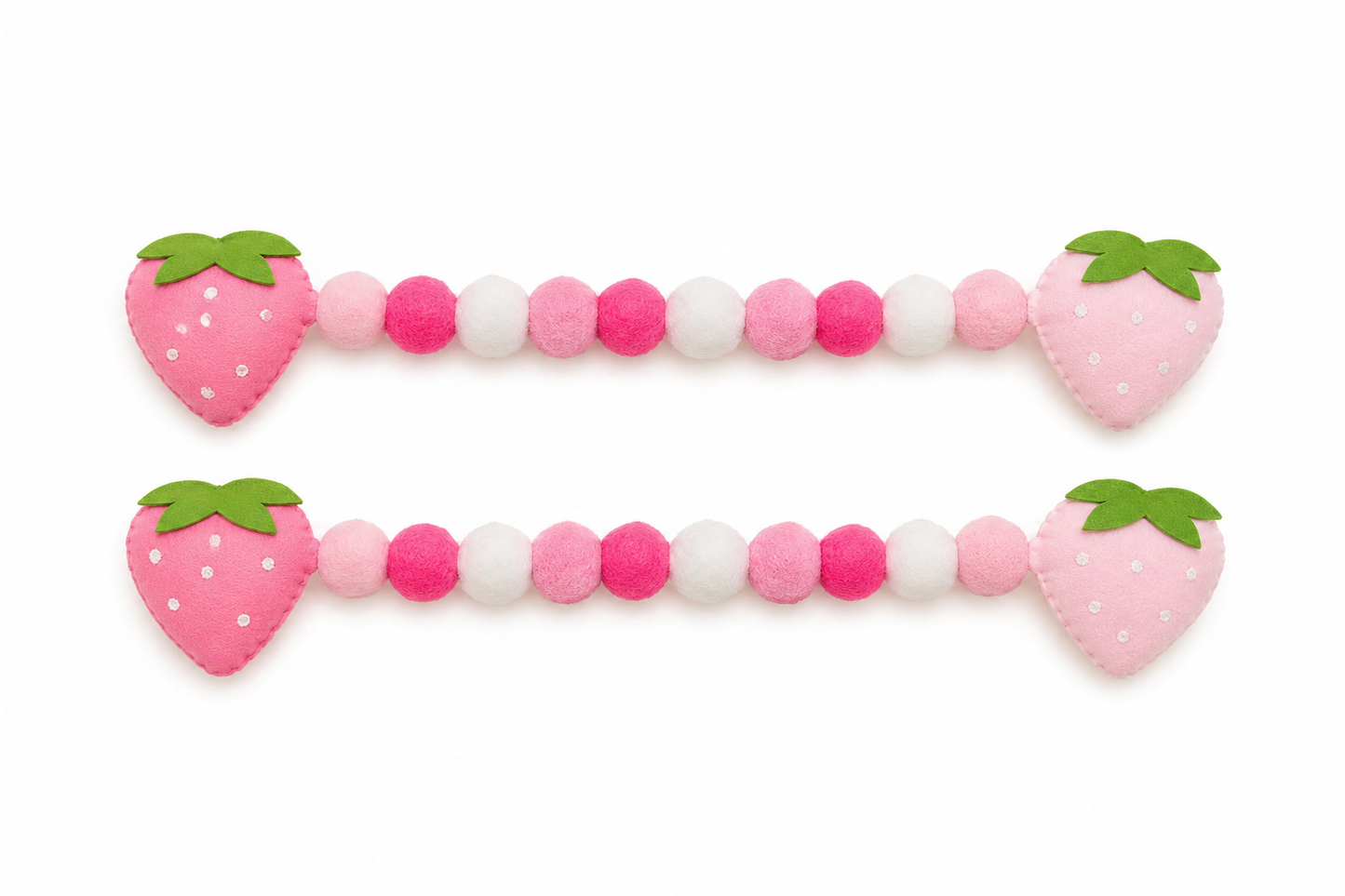 Pink and white beaded toy with strawberry-shaped ends on a white background