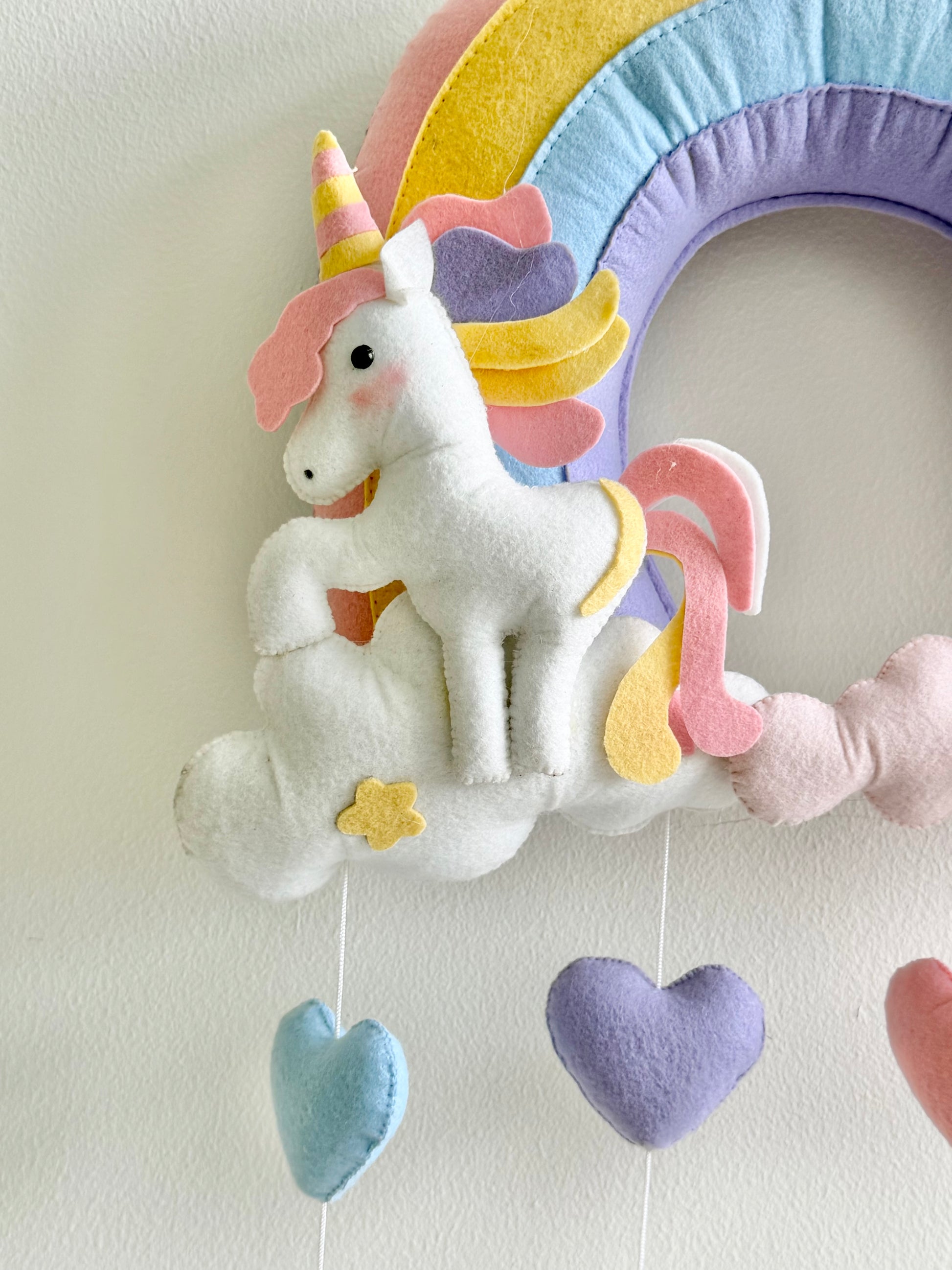 Children's wall decoration with a unicorn, rainbow, and clouds on a light background
